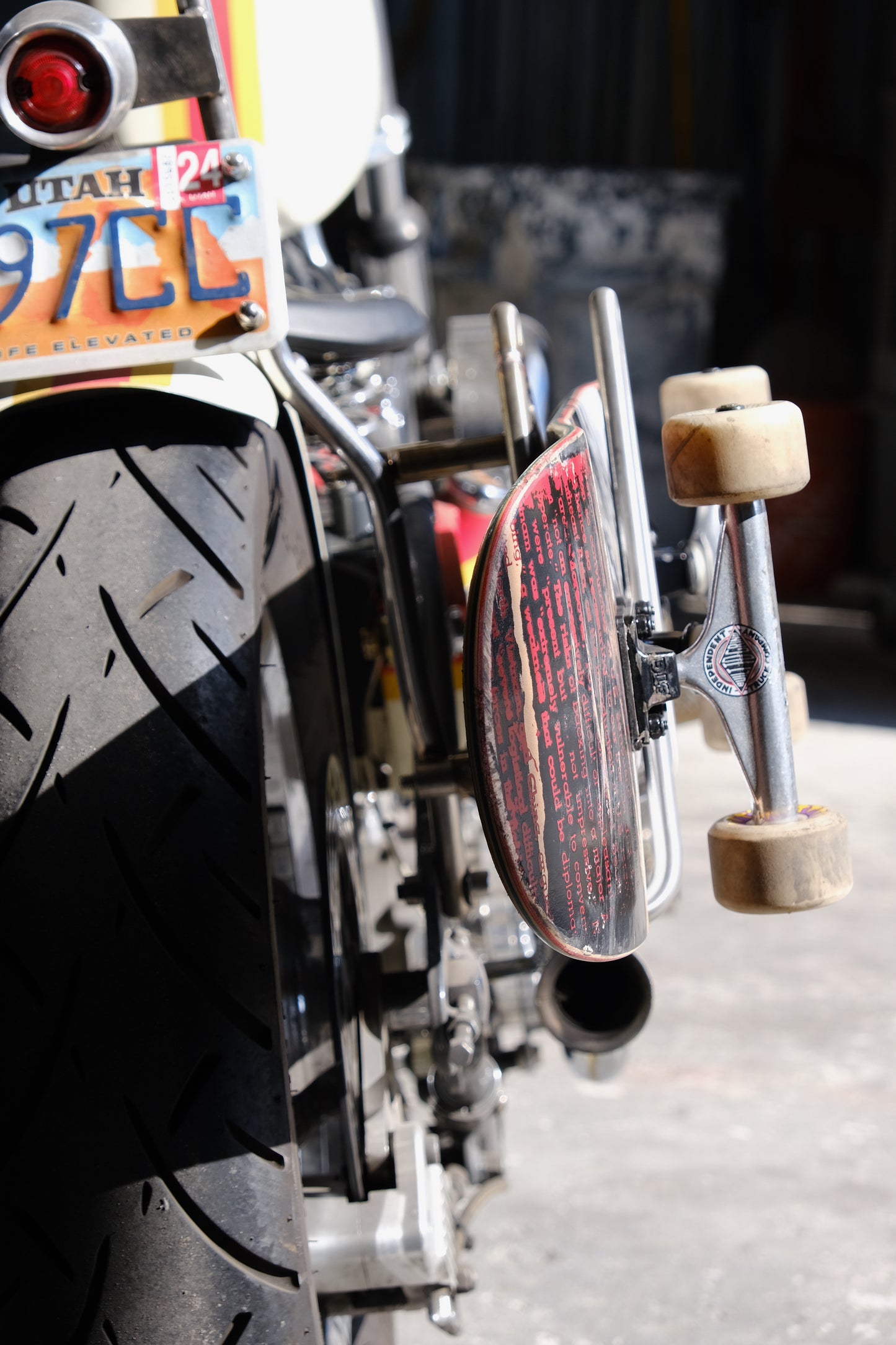 Edward Richie Motorcycle Skateboard rack in stainless steel with a skateboard in it mounted on a custom harley back view